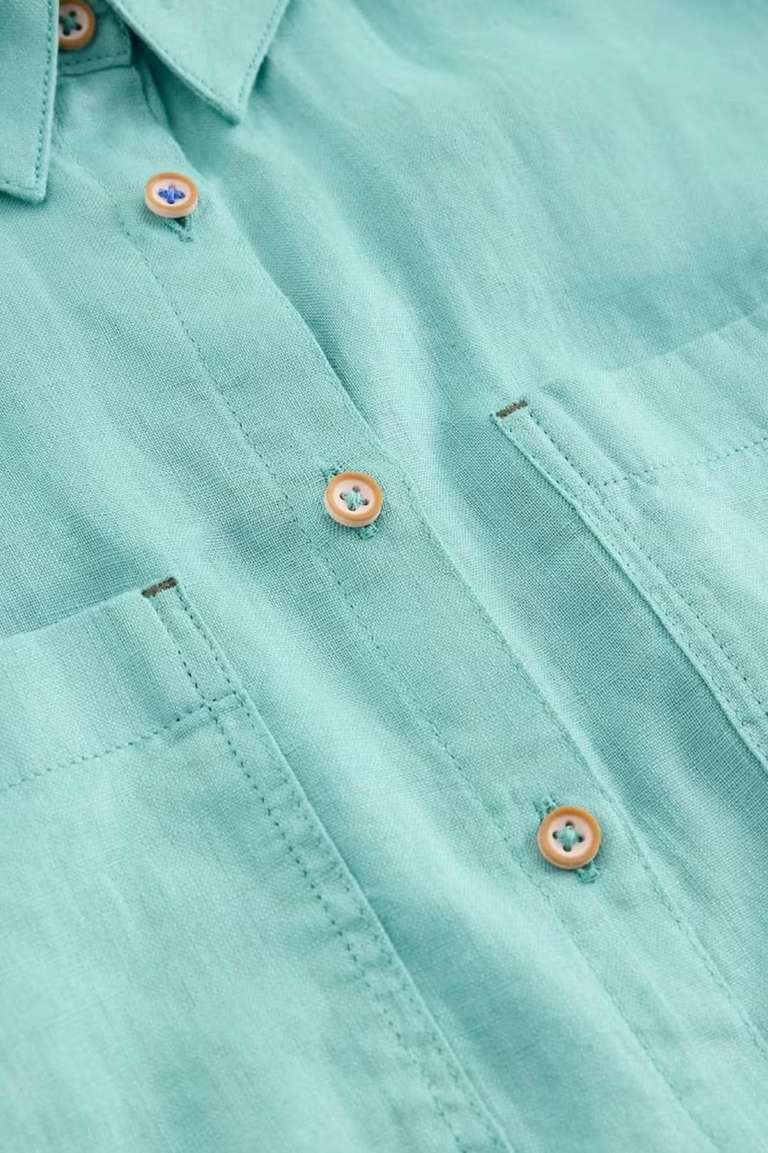 Chemise en lin Sophie avec boutons détachables et col classique, détaillant le tissu vert léger et respirant pour un confort quotidien.