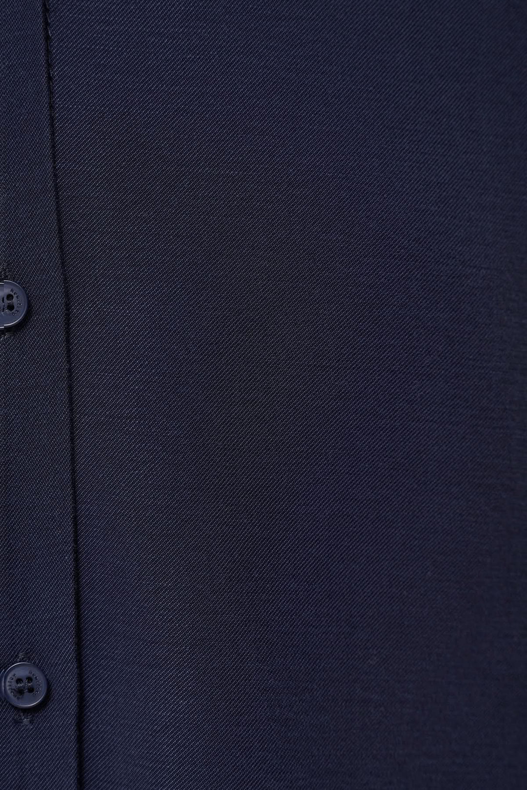 Détail de tissu bleu marine de chemise fluide avec boutons, élégante et confortable.