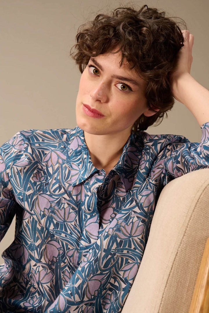 Femme portant une chemise fluide à manches trois-quarts avec imprimé décoratif, idéale pour la mi-saison. Mode et style élégants.