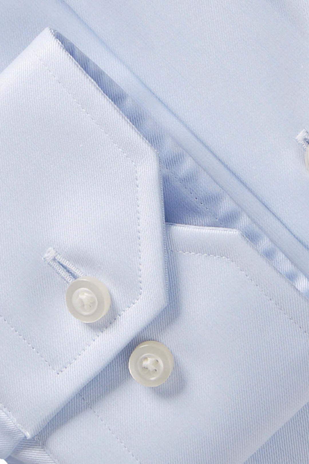 Détails d'une chemise habillée en twill fin, col Mr. Crown et boutons élégants, offrant confort et style.