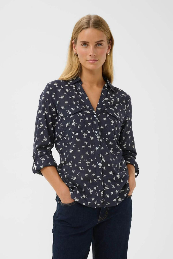 Chemise à imprimé floral Cortnio portée par une femme, coupe droite et col classique, apportant fraîcheur et élégance à une tenue quotidienne.