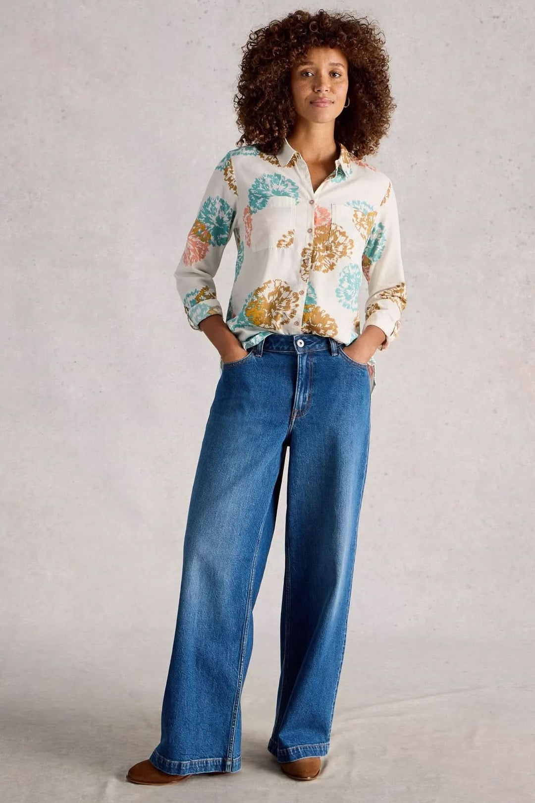 Femme portant la Chemise imprimée coupe décontractée Sophie avec jean large, style casual et moderne, imprimé graphique floral.