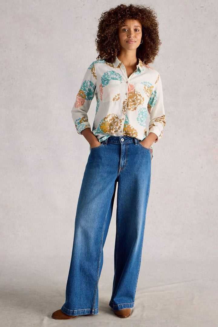 Femme portant la Chemise imprimée coupe décontractée Sophie avec jean large, style casual et moderne, imprimé graphique floral.