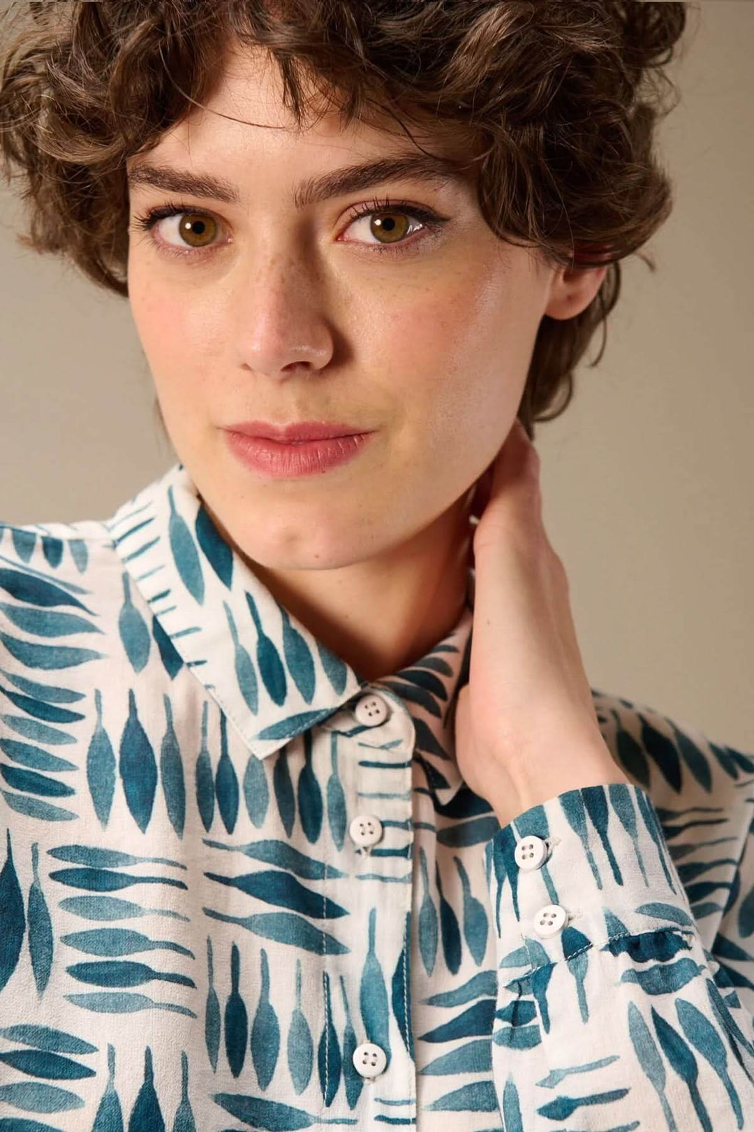 Portrait d'une femme portant une chemise imprimée à manches longues avec un motif graphique.