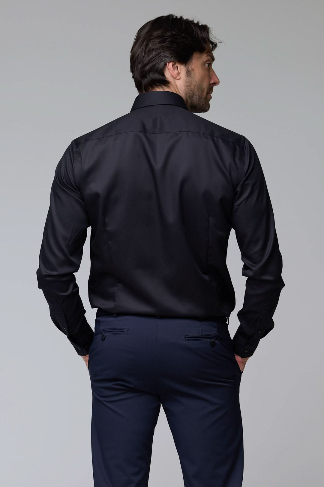 Chemise infroissable de base en satin noir, coupe ajustée pour une élégance moderne.