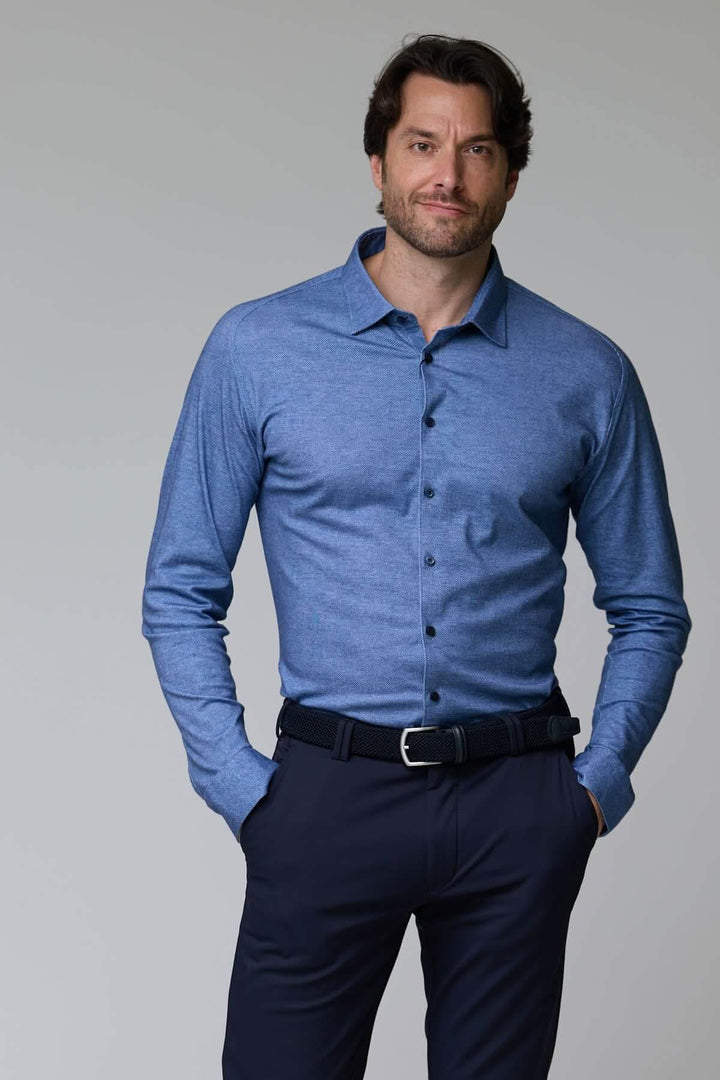 Homme portant une chemise jersey texturé bleue à manches longues, col structuré, style moderne et soigné pour bureau ou sorties décontractées.