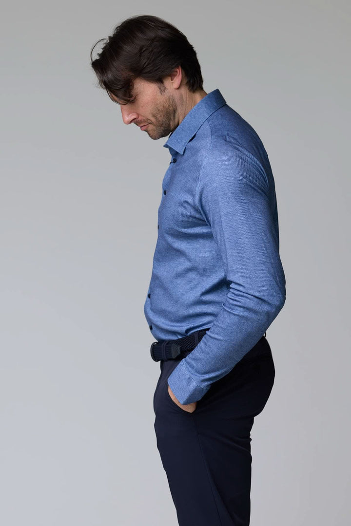 Homme portant une chemise jersey texturé bleue, manches longues, col structuré, coupe ajustée, style moderne pour bureau et sorties décontractées.