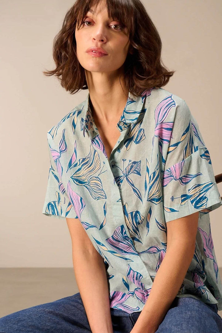 Femme portant une chemise légère à manches courtes avec imprimé, idéale pour un look estival moderne et décontracté.