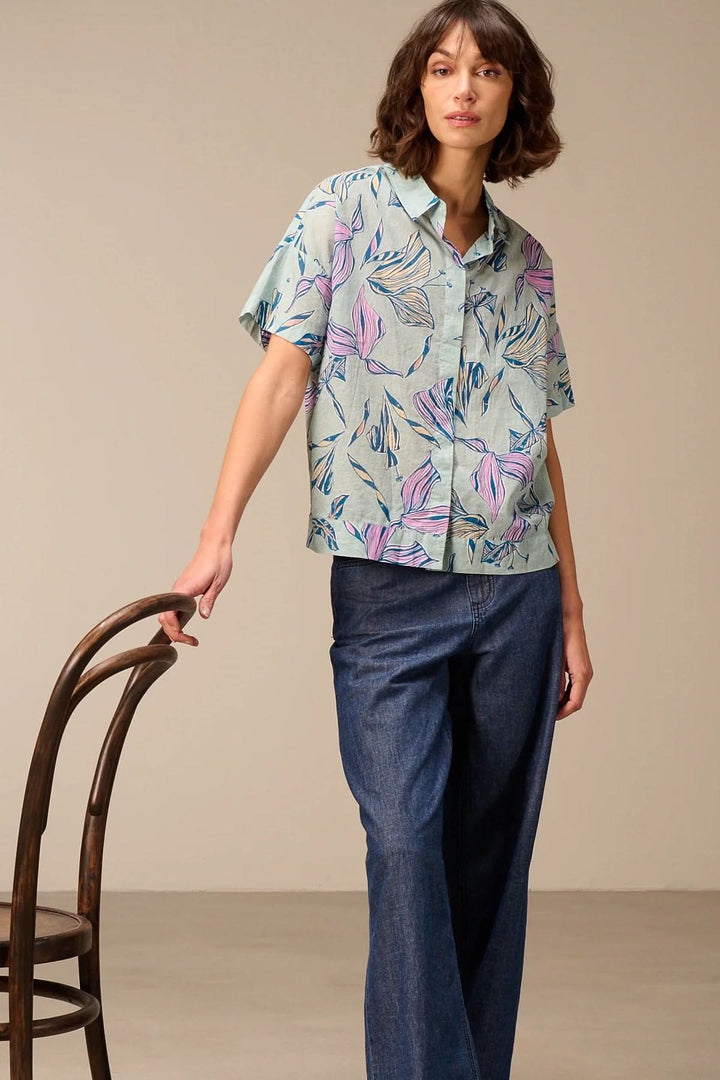Chemise légère à manches courtes avec imprimé portée par un modèle, parfaite pour un look estival et élégant.