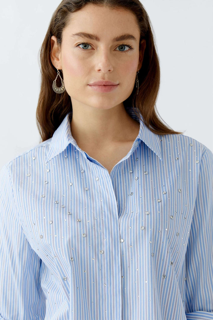 Chemise longue rayée bleue avec galets, col classique, coupe décontractée.