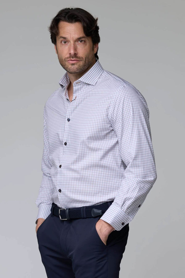 Homme portant une chemise à motif discret avec manches longues et boutons contrastants, offrant une allure contemporaine et élégante.