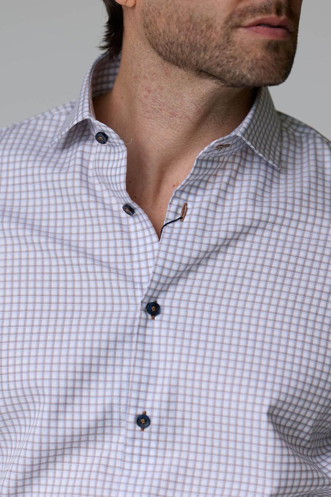 Homme portant une chemise à motif discret avec boutons contrastants en ton bois.