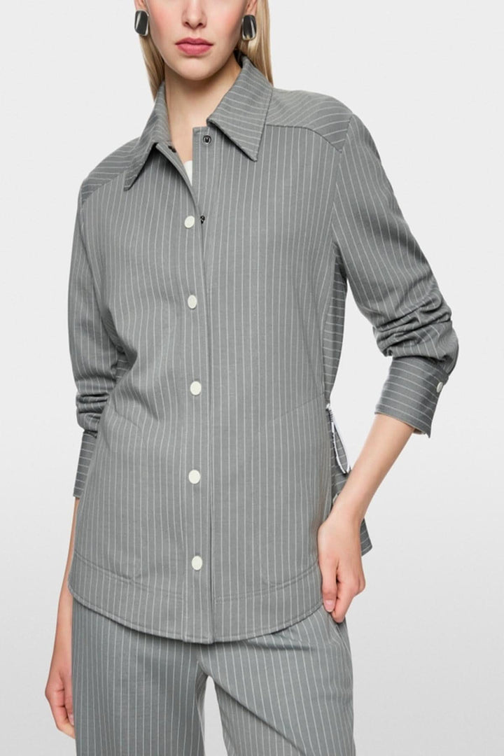 Chemise rayée décontractée avec motif à rayures et poches latérales, col classique, poignets et patte de boutonnage.