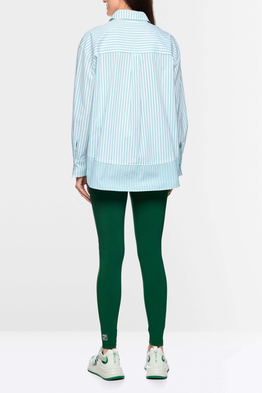 Chemise rayée en coton moderne avec coupe ample et col structuré, associée à un look décontracté.