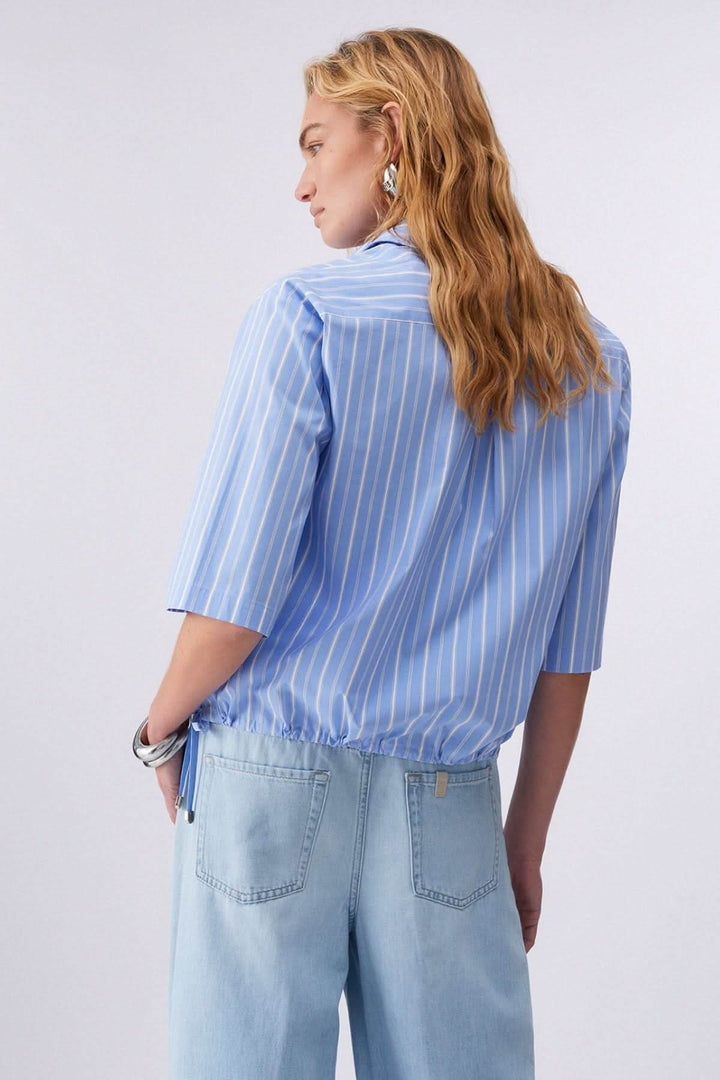 Femme portant une chemise rayée à manches courtes avec col classique et fermeture boutonnée, vue de dos.