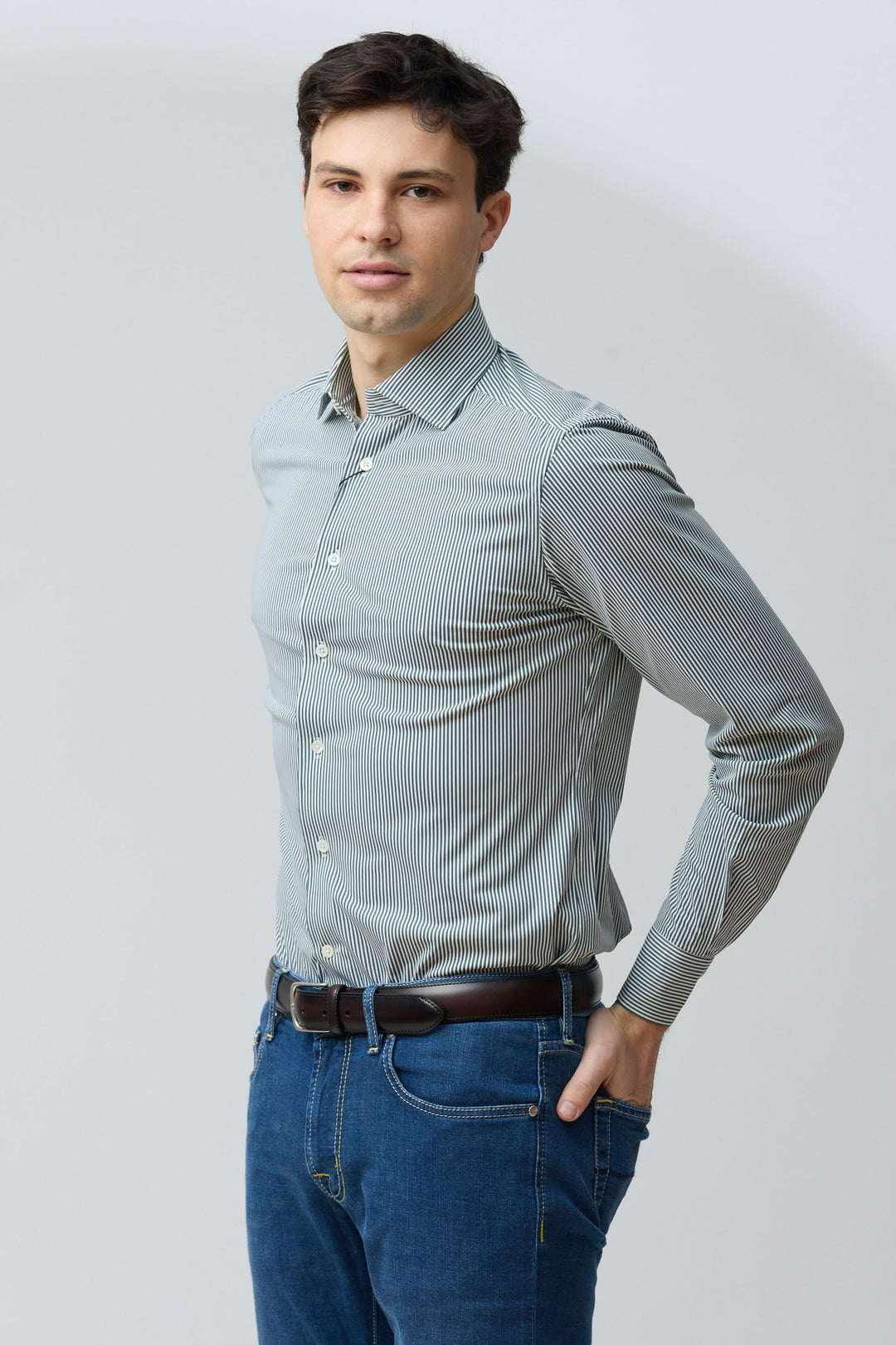 Homme portant une chemise à rayures vertes fines, coupe ajustée, look moderne et soigné, idéal pour style professionnel ou décontracté.