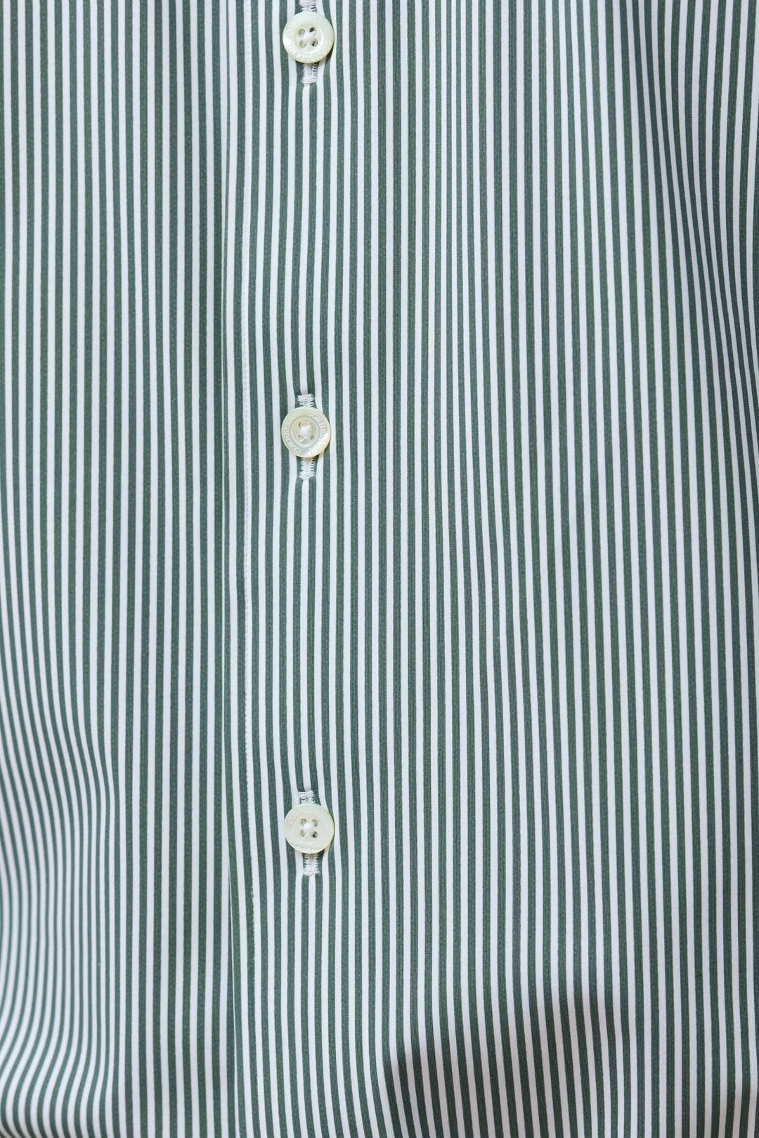 Chemise à rayures vertes fines avec boutons blancs, coupe ajustée pour un look moderne et élégant, offrant confort et style professionnel.