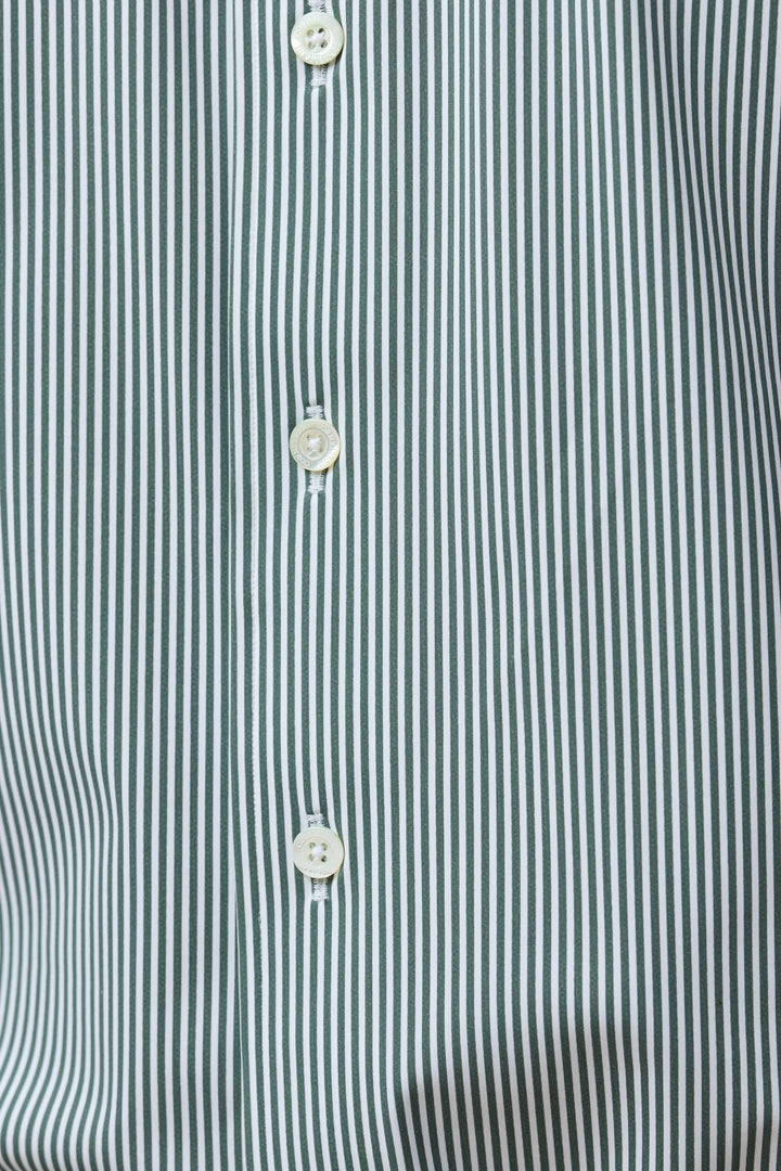 Chemise à rayures vertes fines avec boutons blancs, coupe ajustée pour un look moderne et élégant, offrant confort et style professionnel.