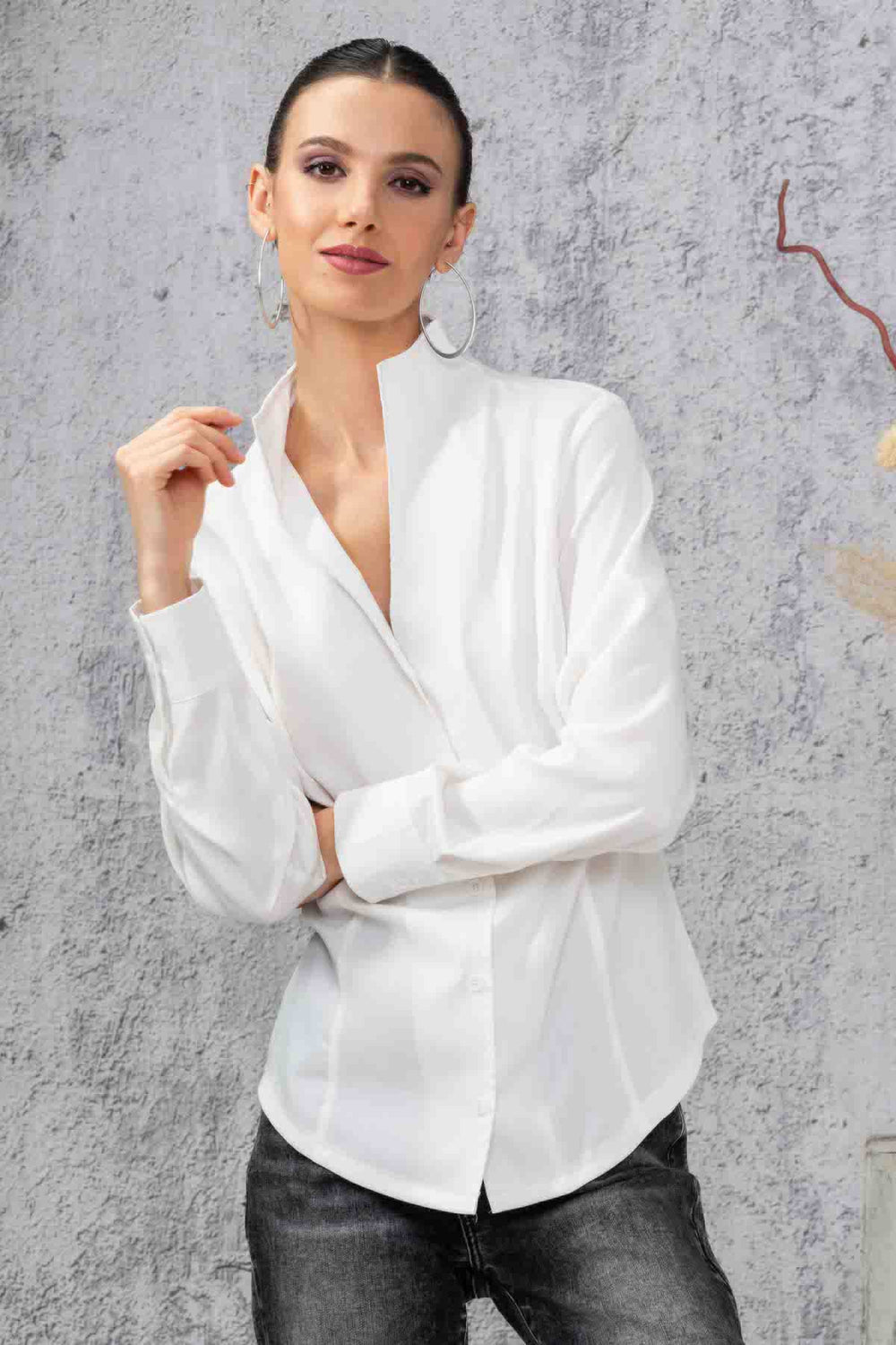 Chemise simple blanche à manches longues, coupe régulière, look élégant avec un fond neutre.