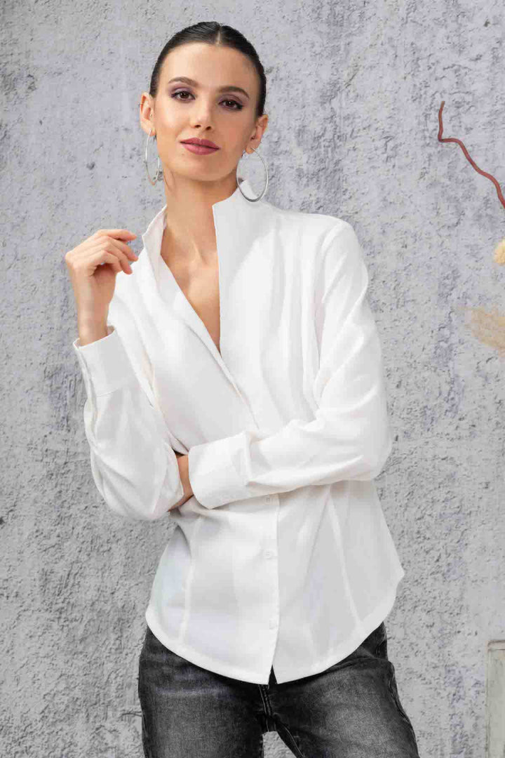 Chemise simple blanche à manches longues, coupe régulière, look élégant avec un fond neutre.