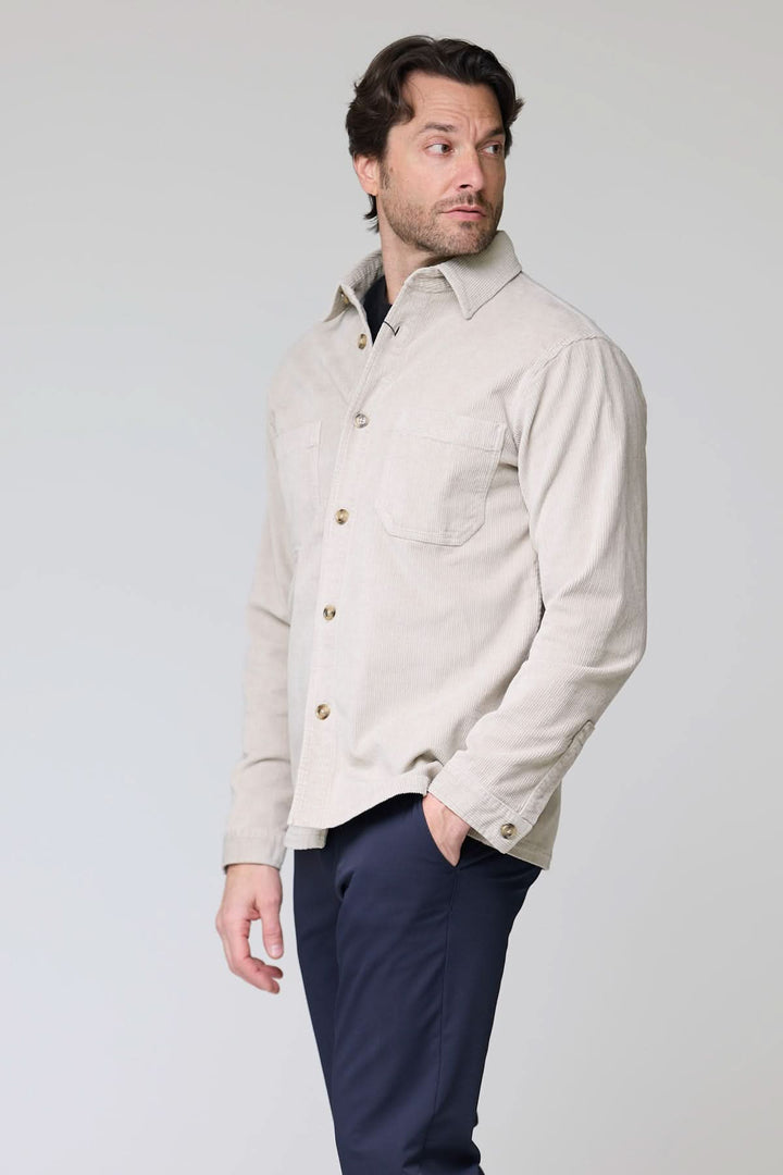 Chemise sport en velours côtelé style surchemise, portée par un homme, avec poches plaquées et col structuré pour un look décontracté.