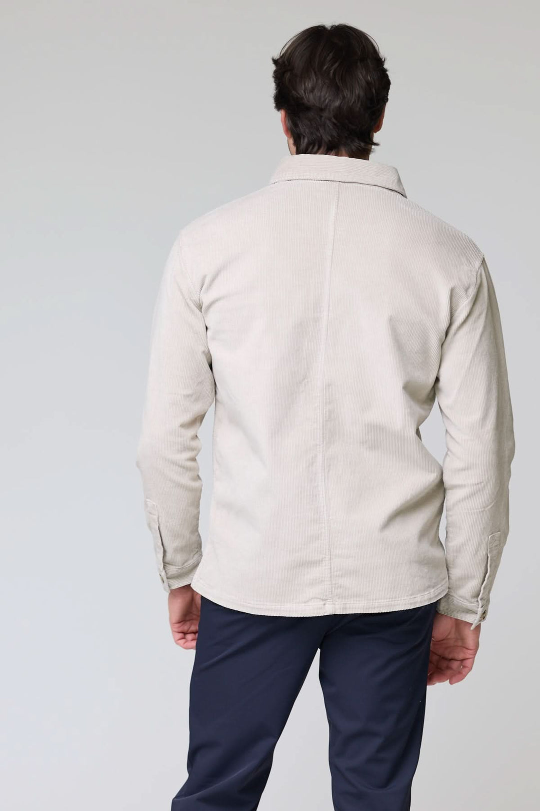 Homme portant une chemise sport en velours côtelé style surchemise vue de dos, design décontracté et sophistiqué, tissu chaud et texturé.