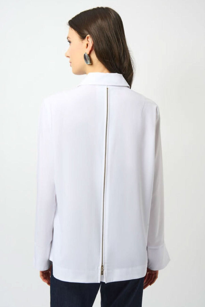 Vue arrière d'un chemisier blanc à manches longues avec fermeture éclair élégante, style moderne et épuré.