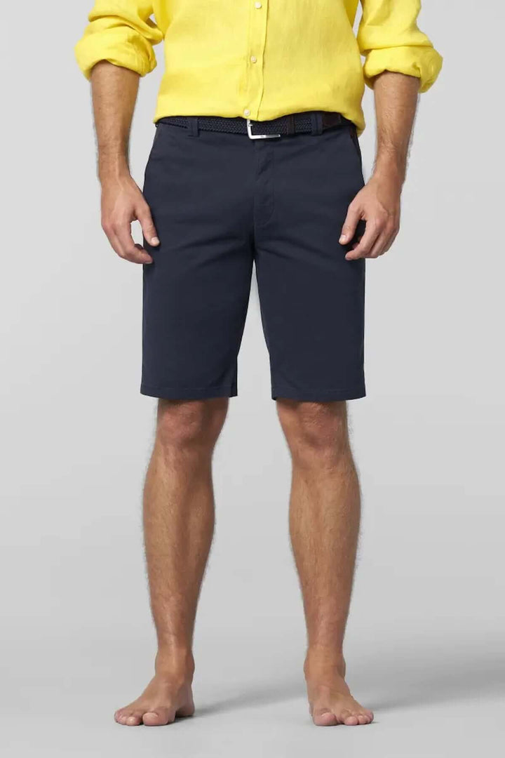 Homme portant un short chino noir au-dessus du genou, avec une chemise jaune, pour un style estival élégant.