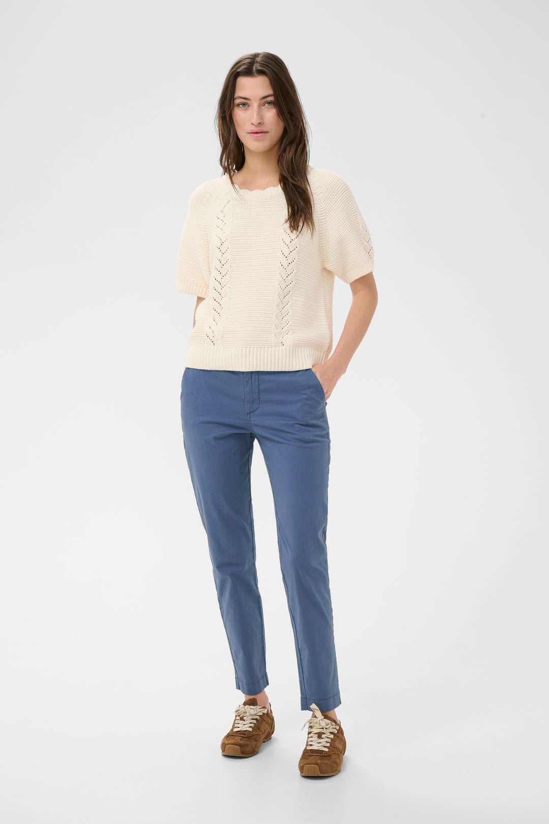 Femme portant un Chino à coupe droite bleu, style moderne et confortable avec longueur cheville, idéal pour plusieurs occasions.