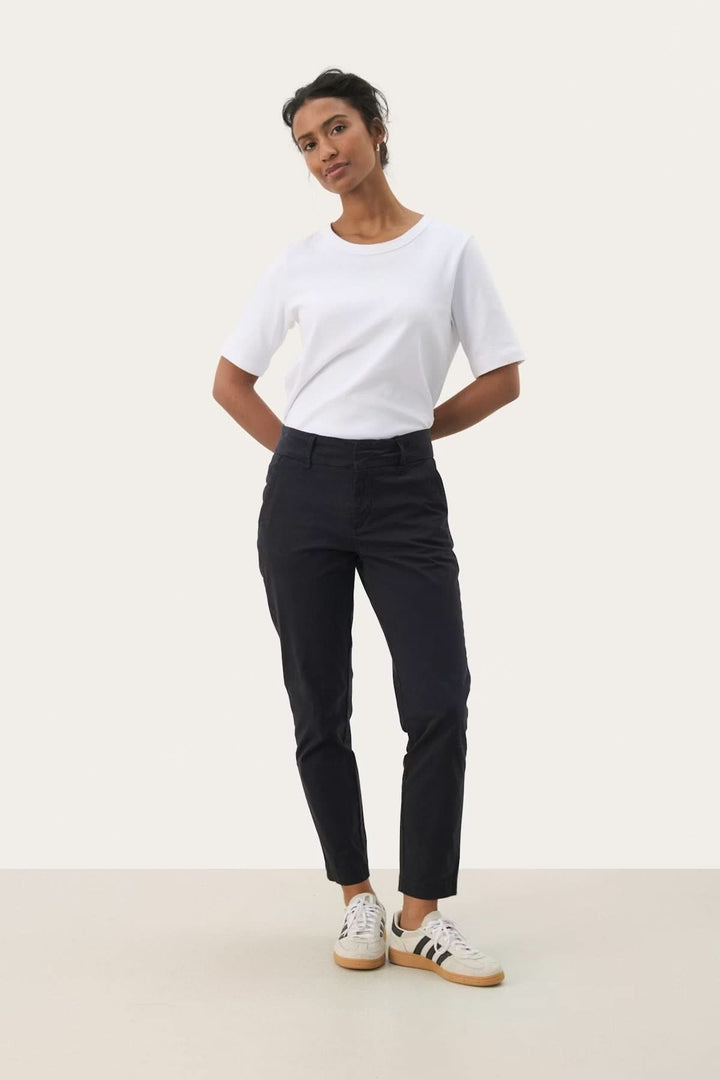 Femme portant un chino à coupe droite noir, coupe moderne et confortable, parfait pour un look élégant et décontracté.