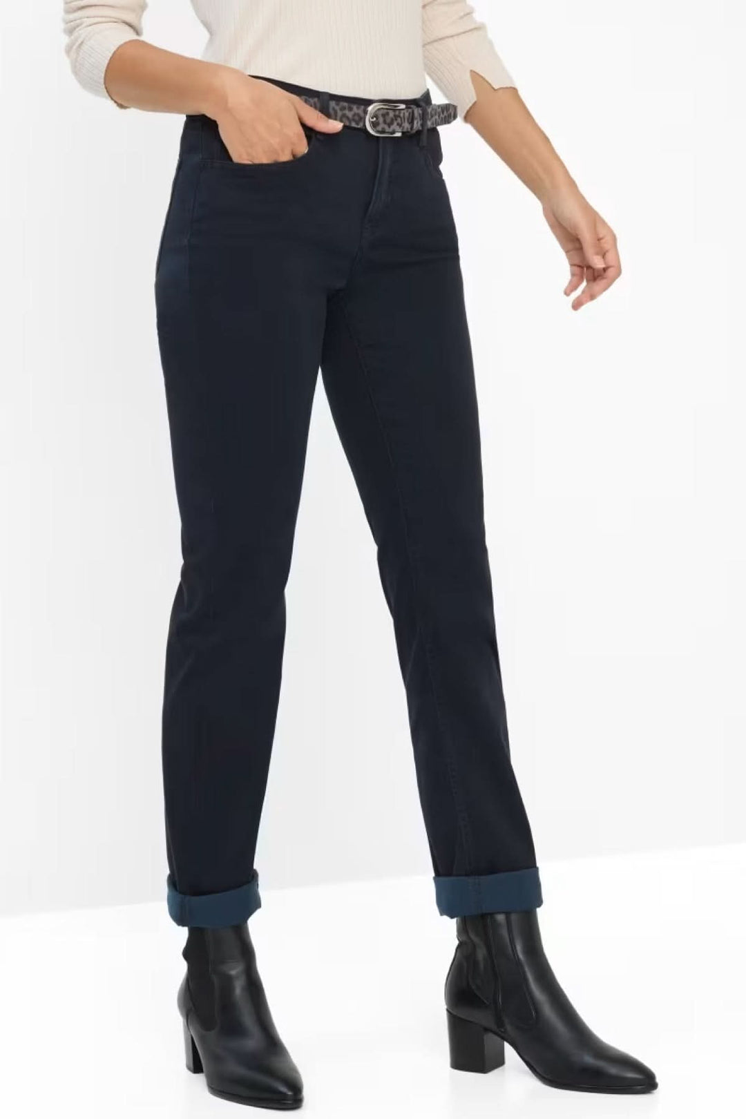 Jean ajusté noir avec ceinture, porté avec des bottines, style décontracté élégant.