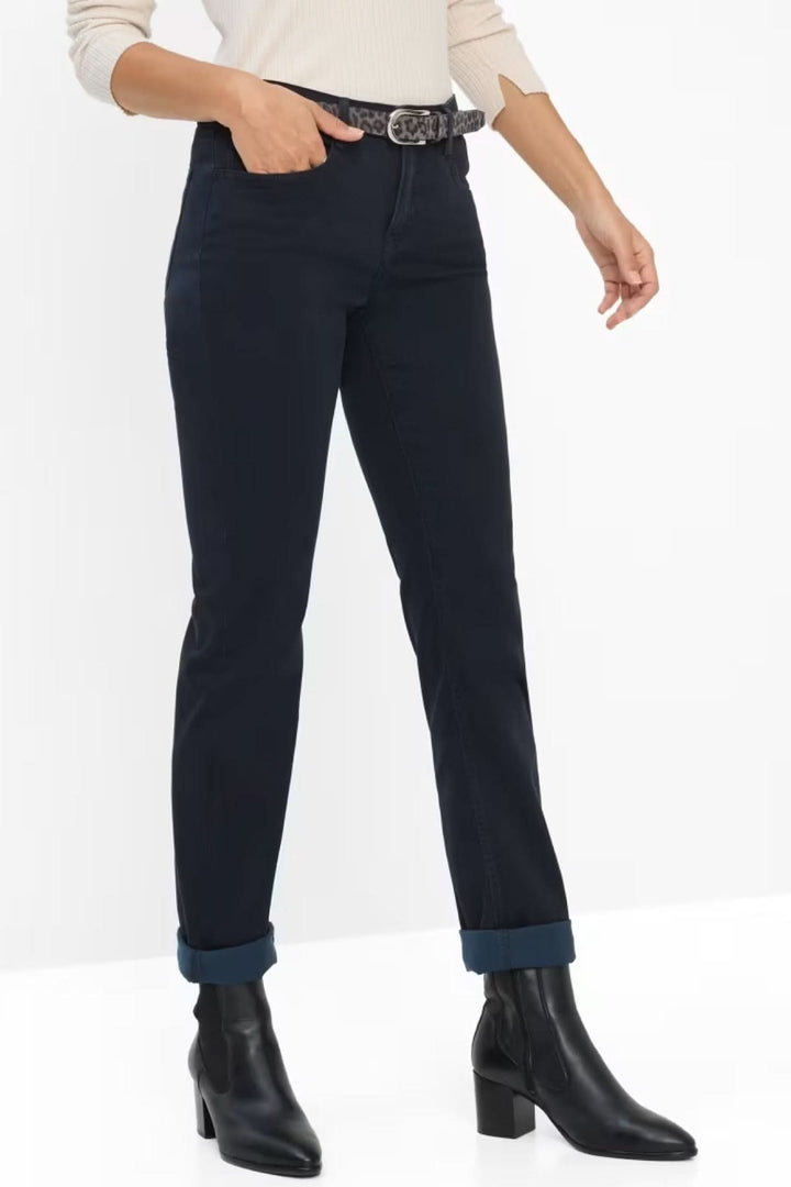 Jean ajusté noir avec ceinture, porté avec des bottines, style décontracté élégant.