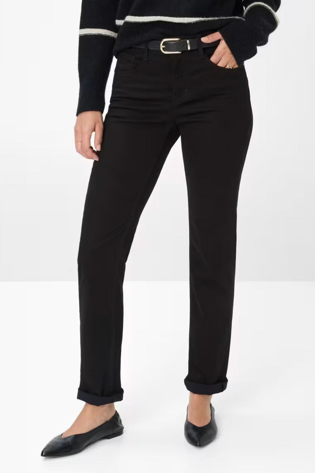 Pantalon chino ajusté noir porté avec une ceinture, offrant un look élégant et décontracté.