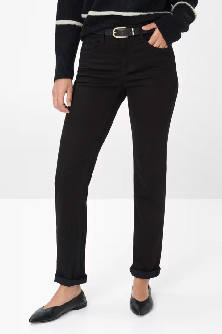 Pantalon chino ajusté noir porté avec une ceinture, offrant un look élégant et décontracté.