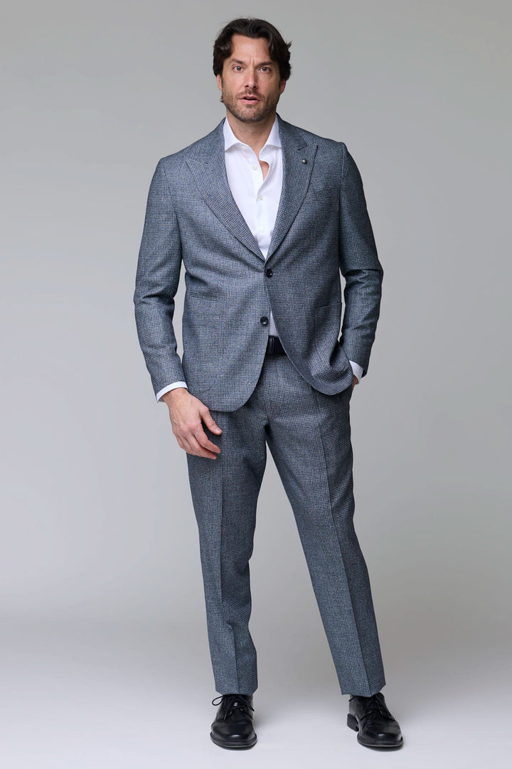 Homme portant un complet à motif micro-carreaux avec veste à deux boutons et pantalon ajusté, idéal pour les événements formels.