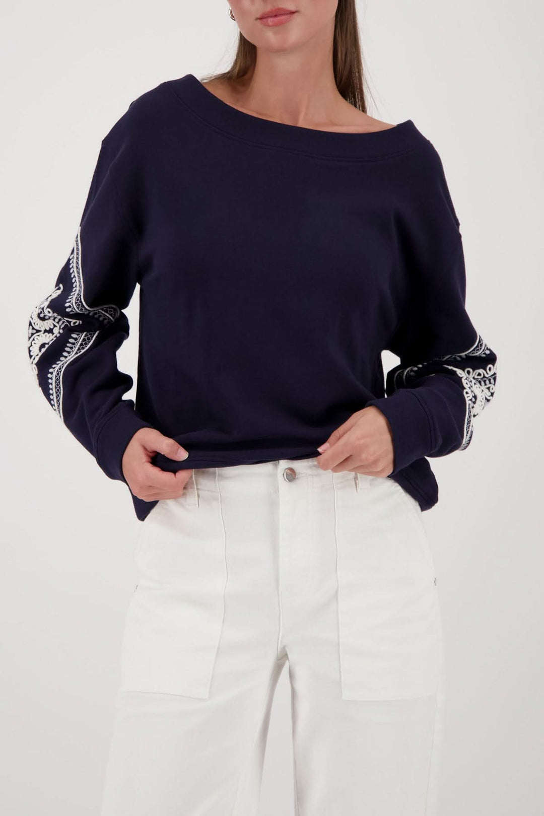 Femme portant un coton ouaté avec broderies décoratives et manche longue, style décontracté moderne, encolure dégagée.