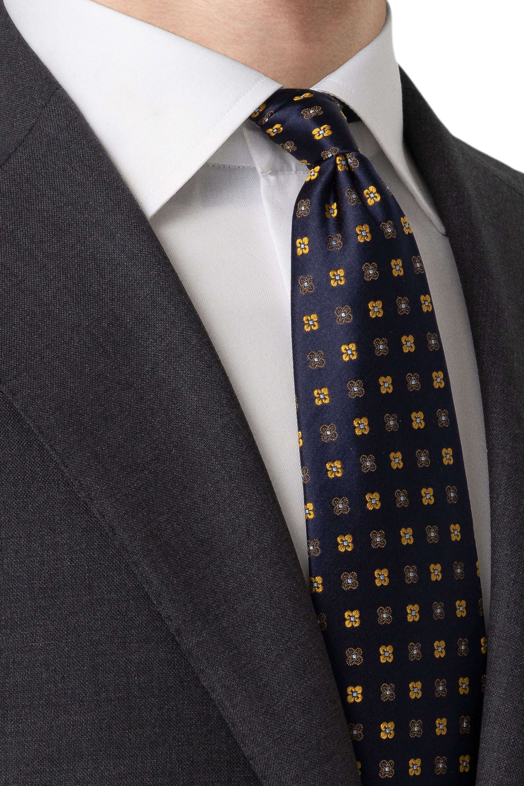 Cravate à motifs floraux géométriques sur un costume gris, ajoutant élégance et raffinement.