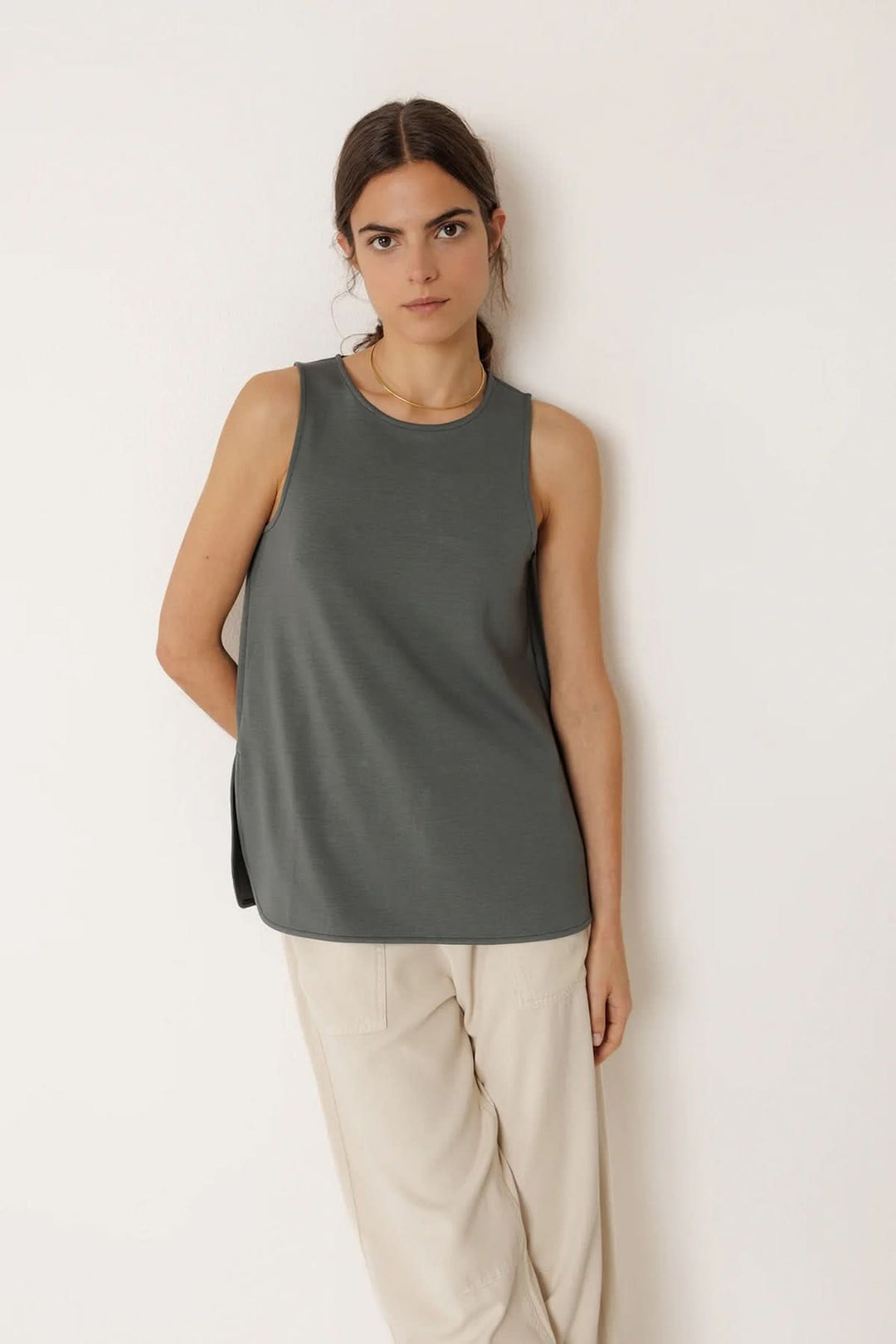 Débardeur minimaliste à coupe fluide porté par une femme, avec encolure arrondie et emmanchures dégagées, style moderne et épuré.