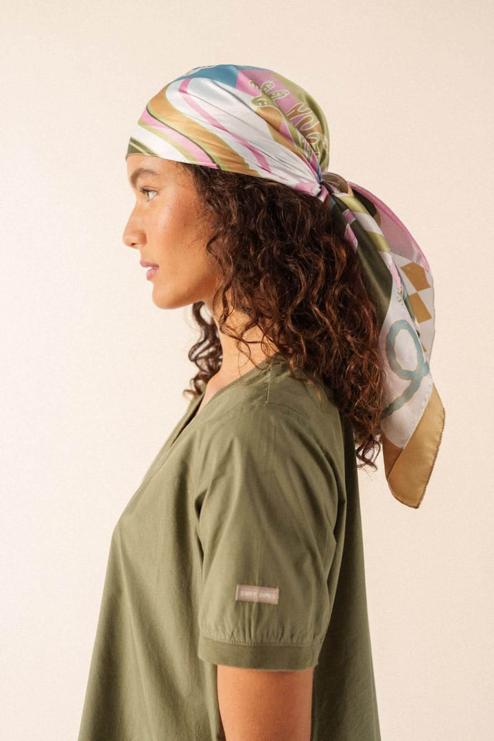 Foulard CARRE FOND MARIN porté sur la tête, motif graphique stylé, ajoute une touche artistique à la tenue, polyvalent et élégant.