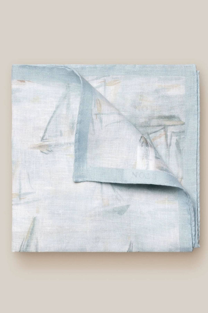 Foulard de poche en lin avec motif de voiliers dans des teintes bleutées et texture légère.
