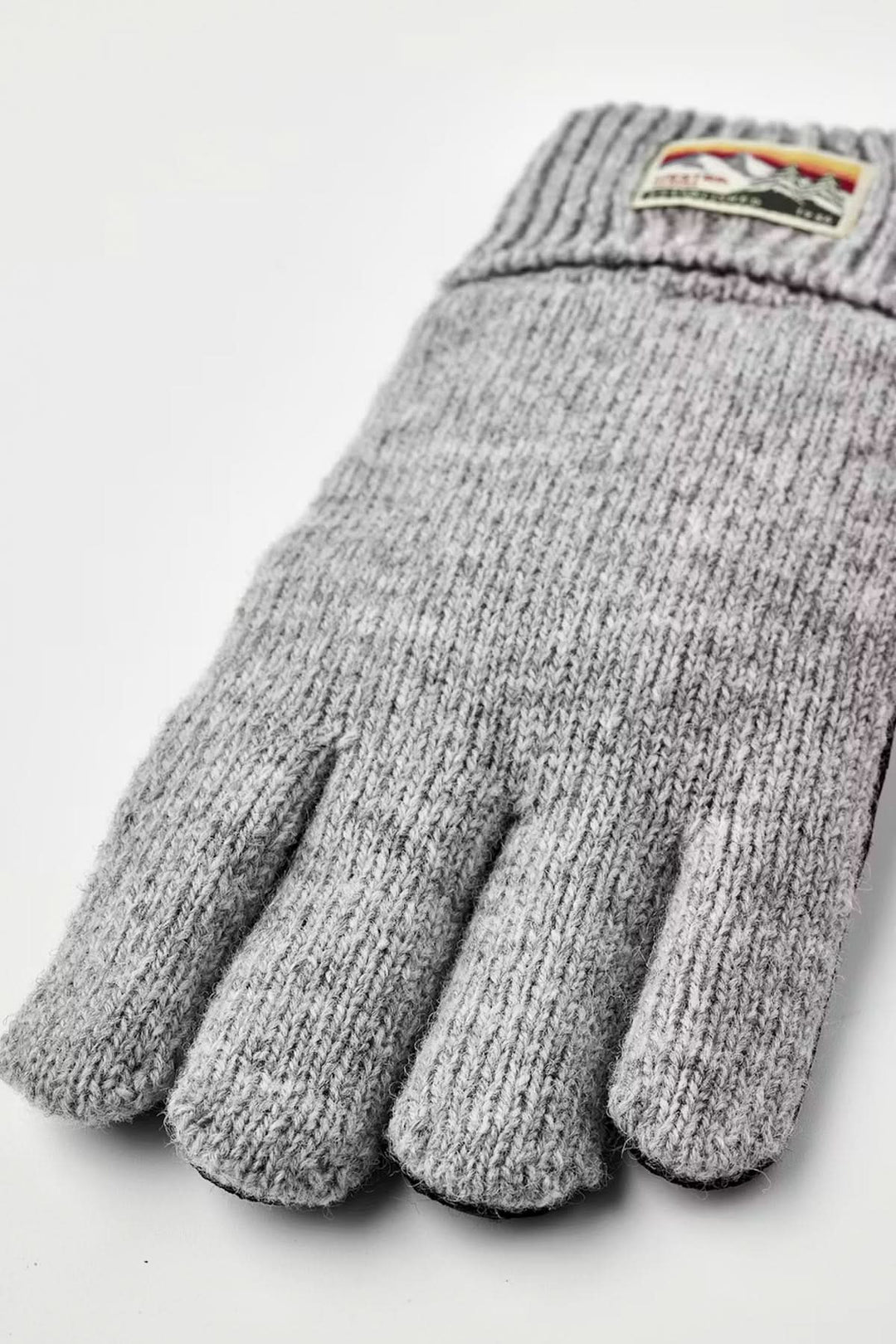 Ganst en maille gris avec maille souple et poignée côtelée, offrant confort et maintien pour les journées fraîches.