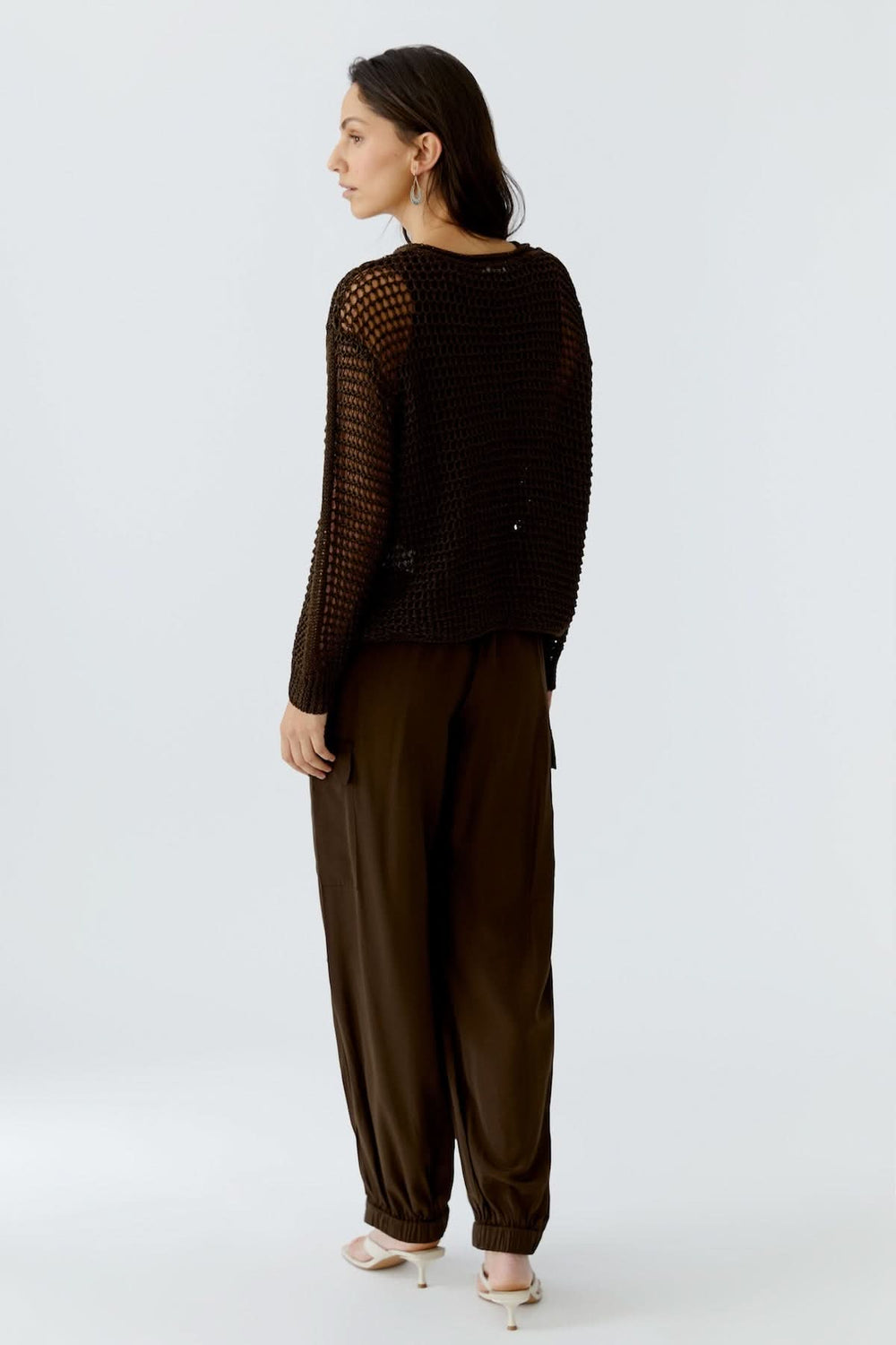 Femme portant un haut coupe moderne essentiel noir avec un pantalon fluide marron, vue de dos
