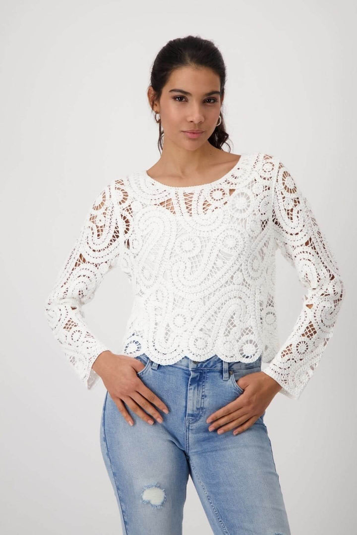 Chandail en crochet blanc en 100% viscose, avec motif unique, manches longues et col rond, porté avec un jean.