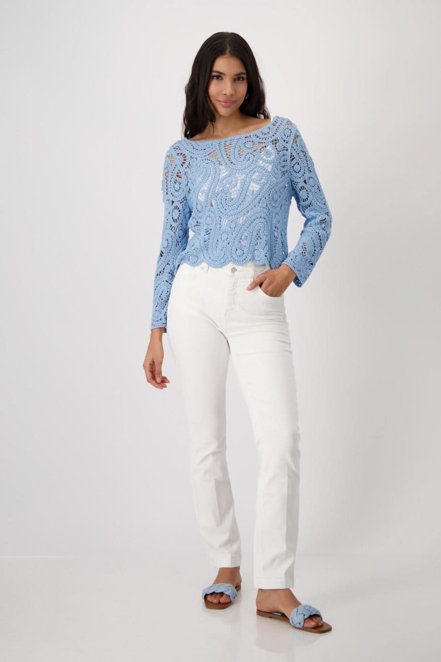 Chandail en crochet bleu avec pantalon blanc, look chic et décontracté, parfait pour une tenue sophistiquée.
