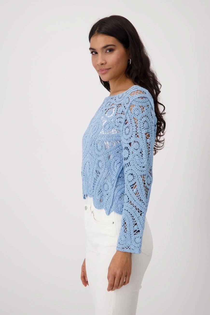 Chandail en crochet bleu clair, long manches, coupe régulière, élégant et confortable, porté avec pantalon blanc.