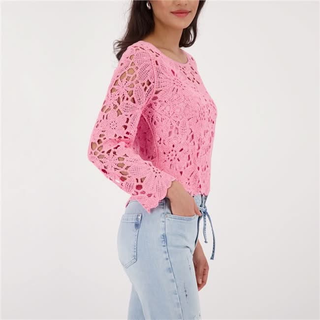 Haut en tricot ajouré rose avec motif floral, encolure ronde, porté avec un jean, élégant et moderne.