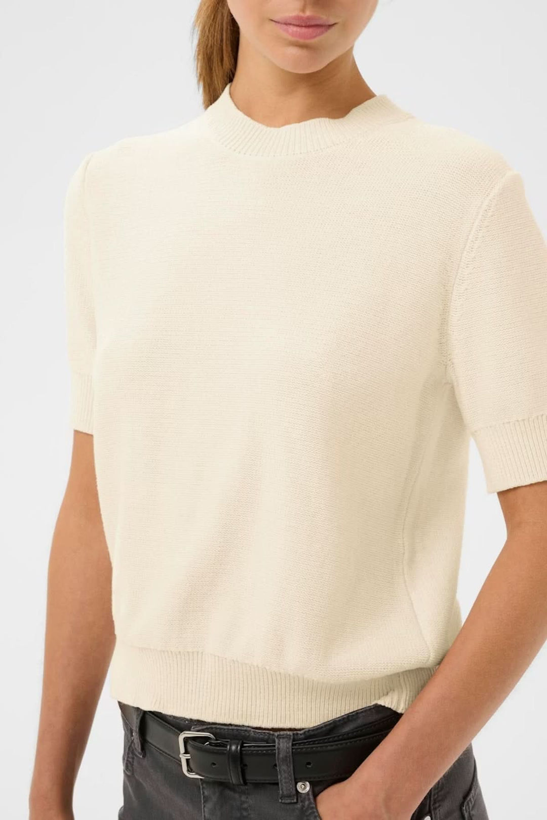 Haut à manches courtes NAASU en maille fine, style épuré avec encolure arrondie. Coupe droite élégante idéale pour le quotidien.