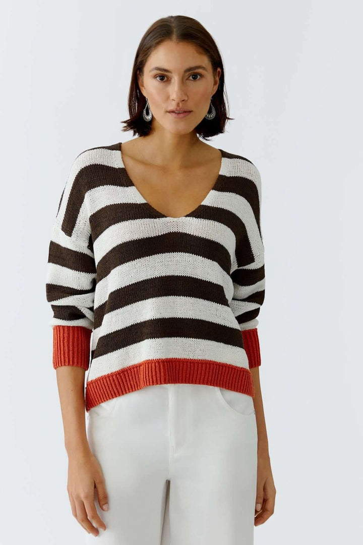 Femme portant un haut tricot rayures modernes avec manches trois-quarts et encolure ronde dans un style décontracté.