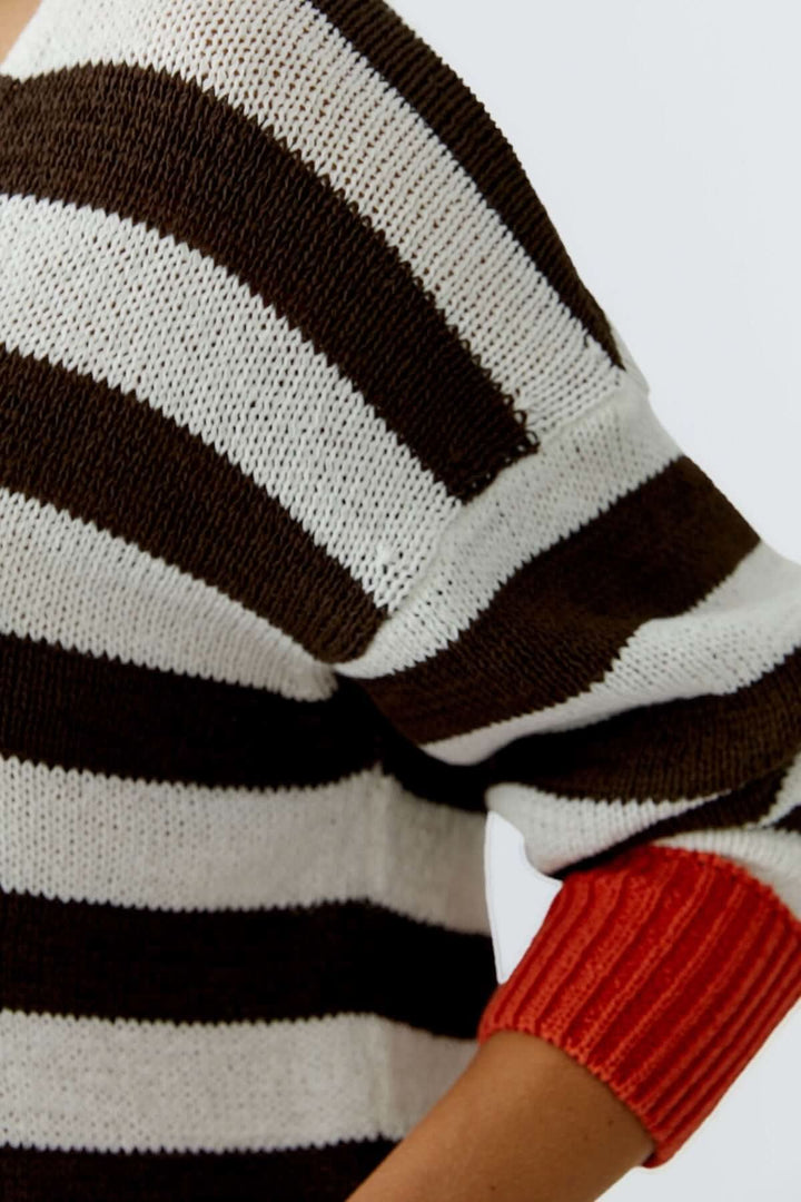 Haut tricot rayures modernes avec manches contrastées en motif dynamique pour une allure décontractée et actuelle.