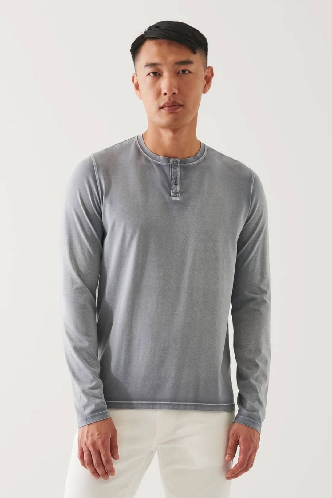 Homme portant un henley en coton stretch vintage wash, à manches longues, couleur gris, avec coupe décontractée.